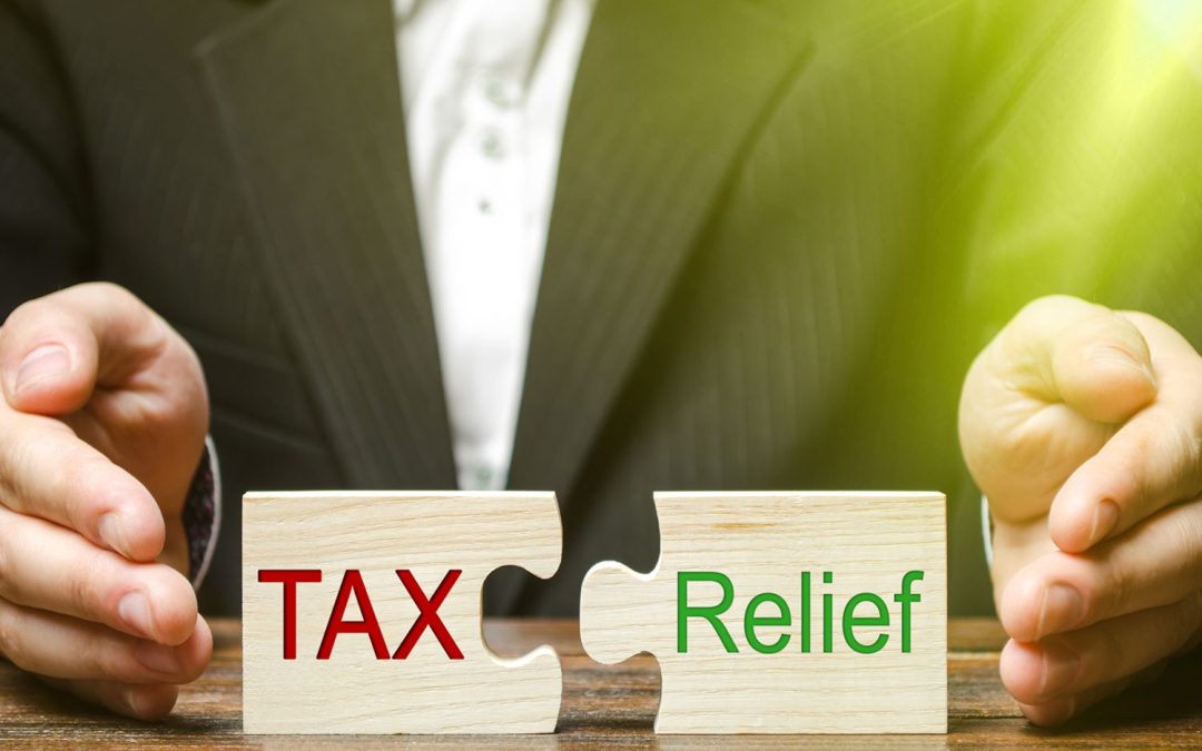 A person is holding a puzzle piece with the words tax relief on it.